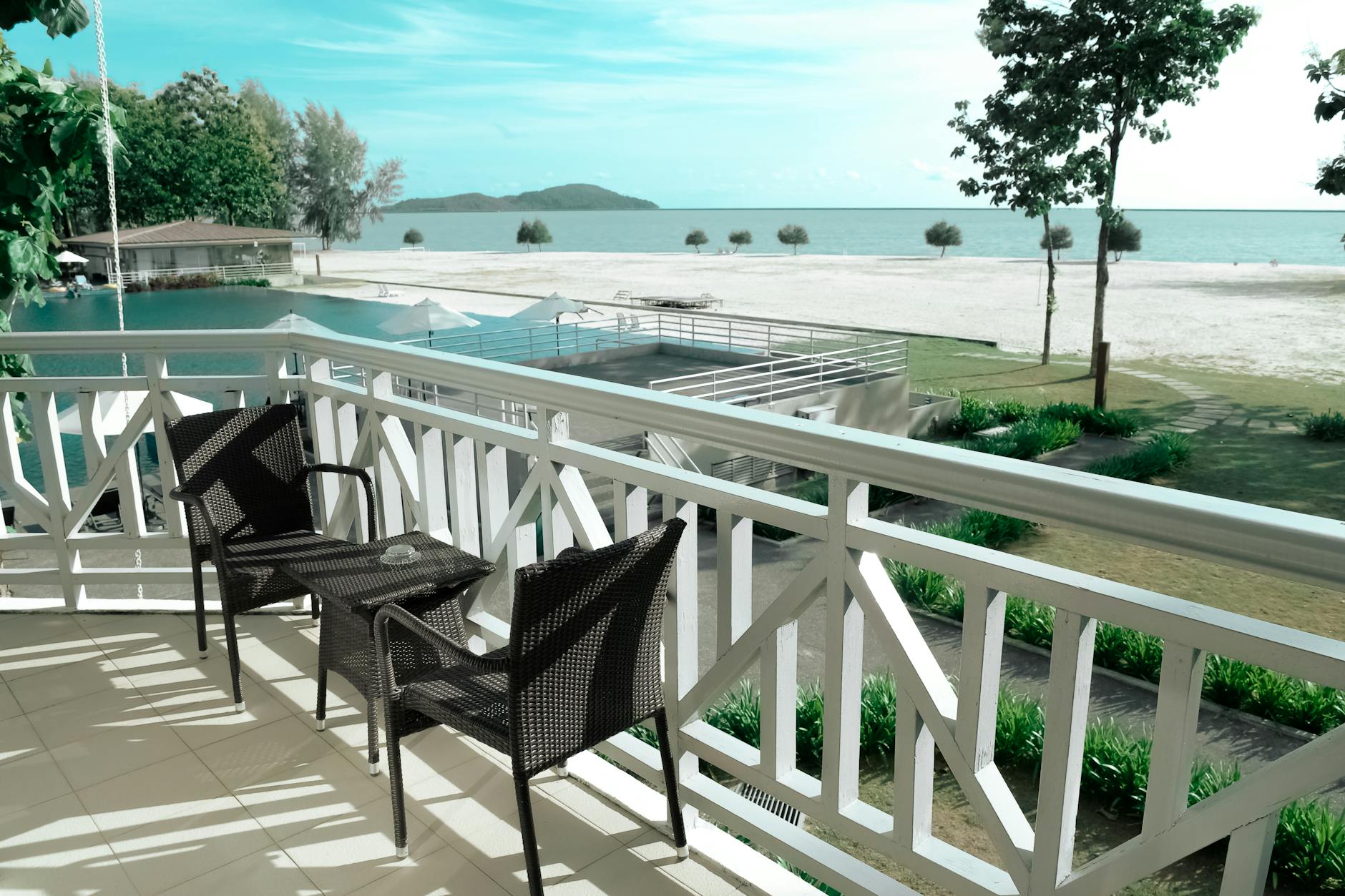 black wicker bistro set on white terrace near ocean