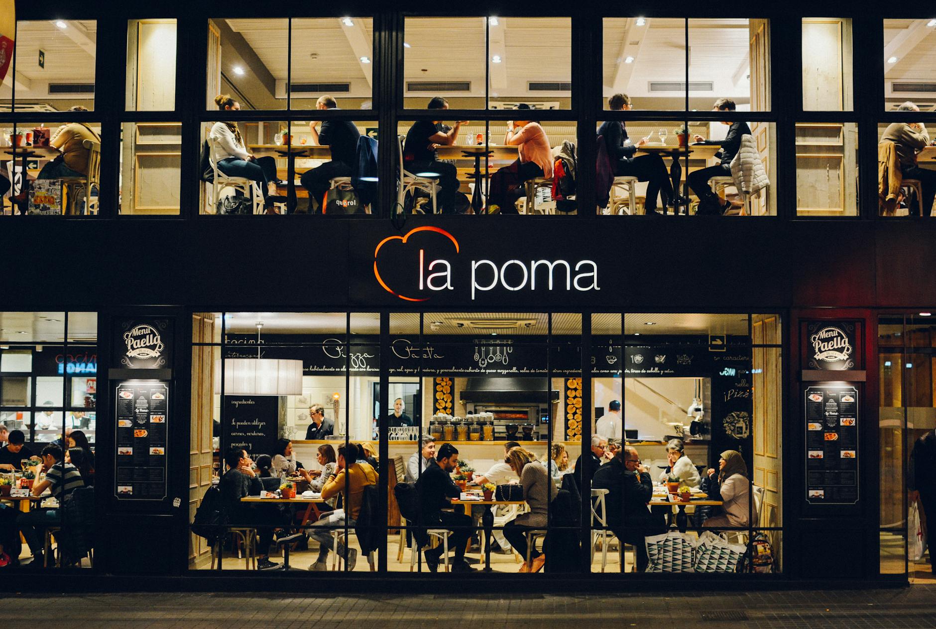 people at la poma store front at night