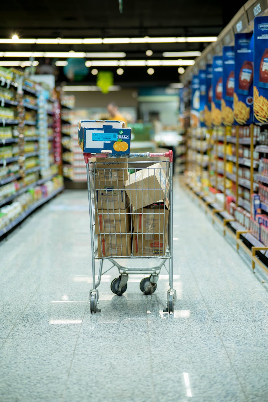 shopping cart filled with packages in empty aisle