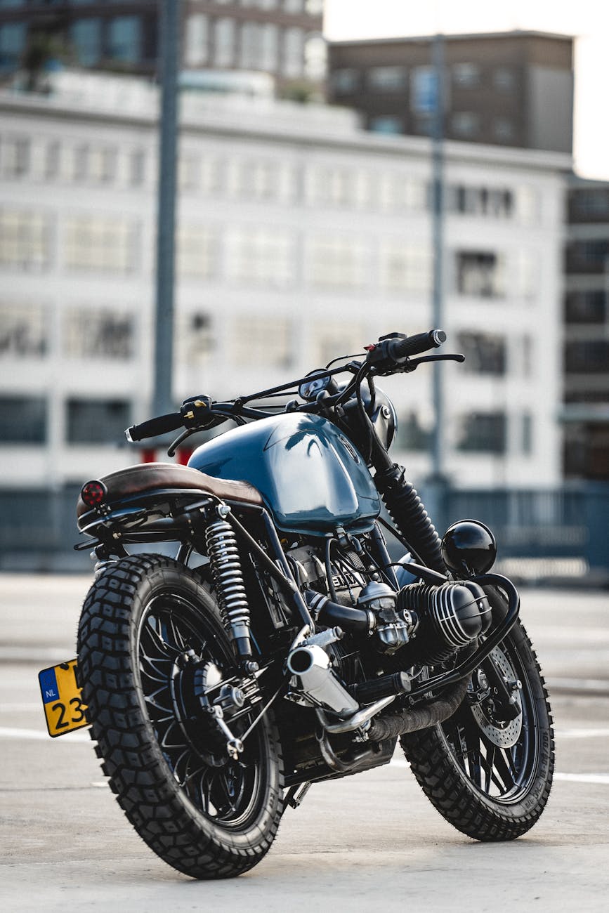 selective focus photo of parked blue and black cafe racer motorcycle