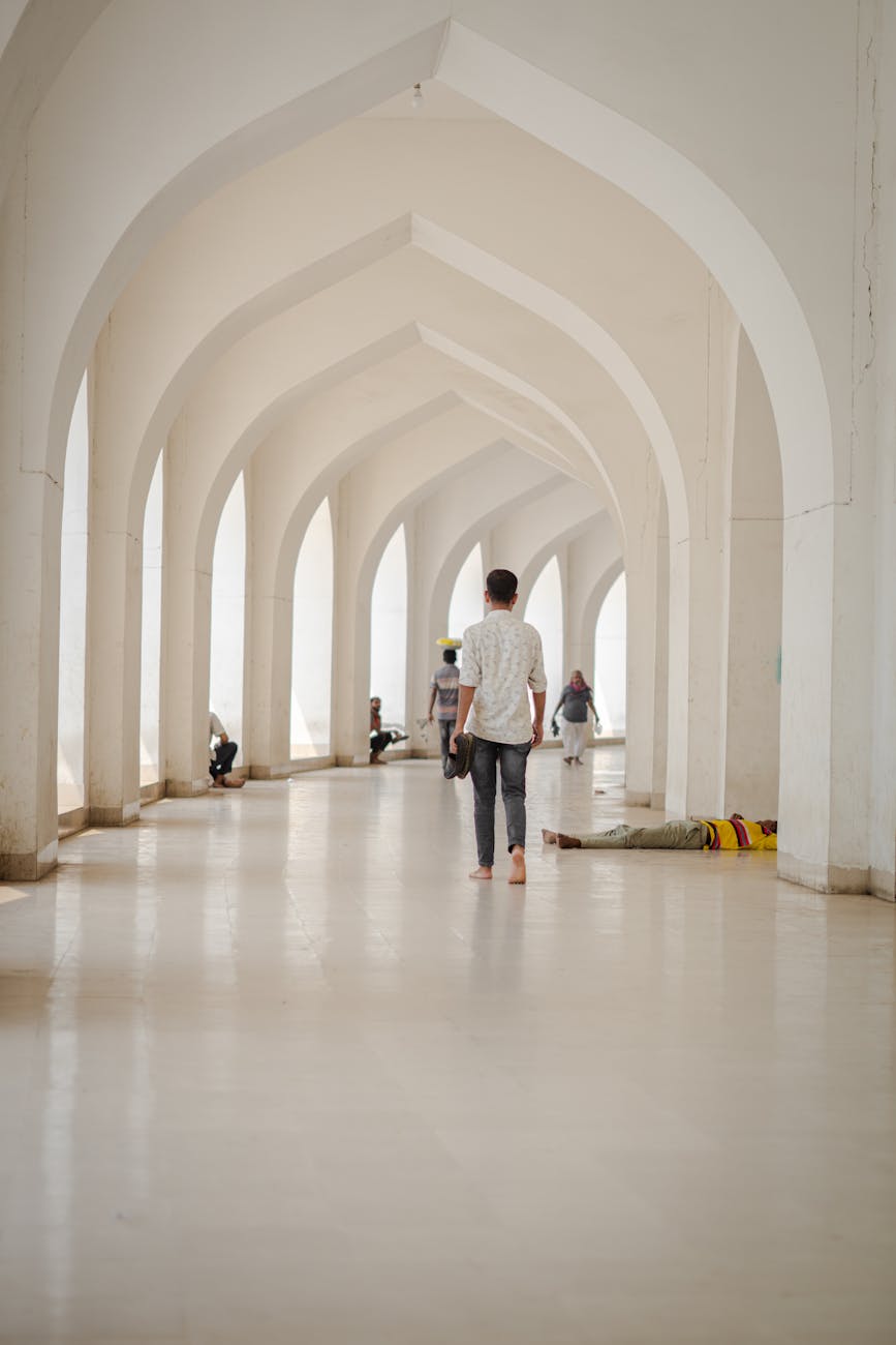 man walking in grand architectural hallway