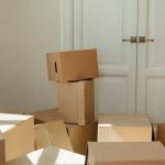 brown cardboard boxes near white wooden cabinet
