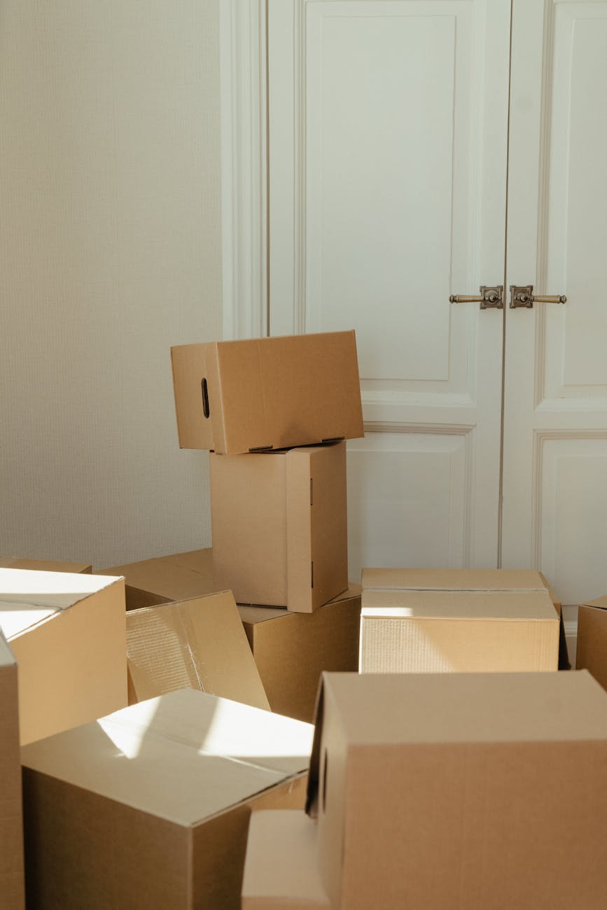 brown cardboard boxes near white wooden cabinet
