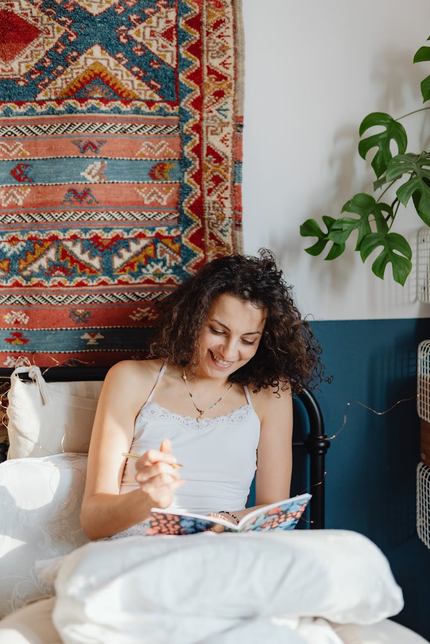 a woman smiling and sitting on the bed