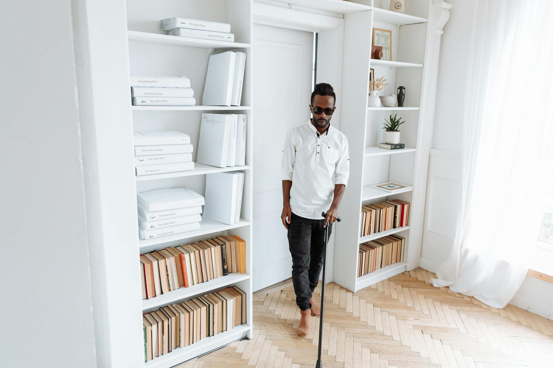 man in white long sleeve shirt holding black walking stick