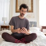 a man looking at his smartphone on the bed