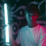 a man in white crew neck shirt holding fluorescent light