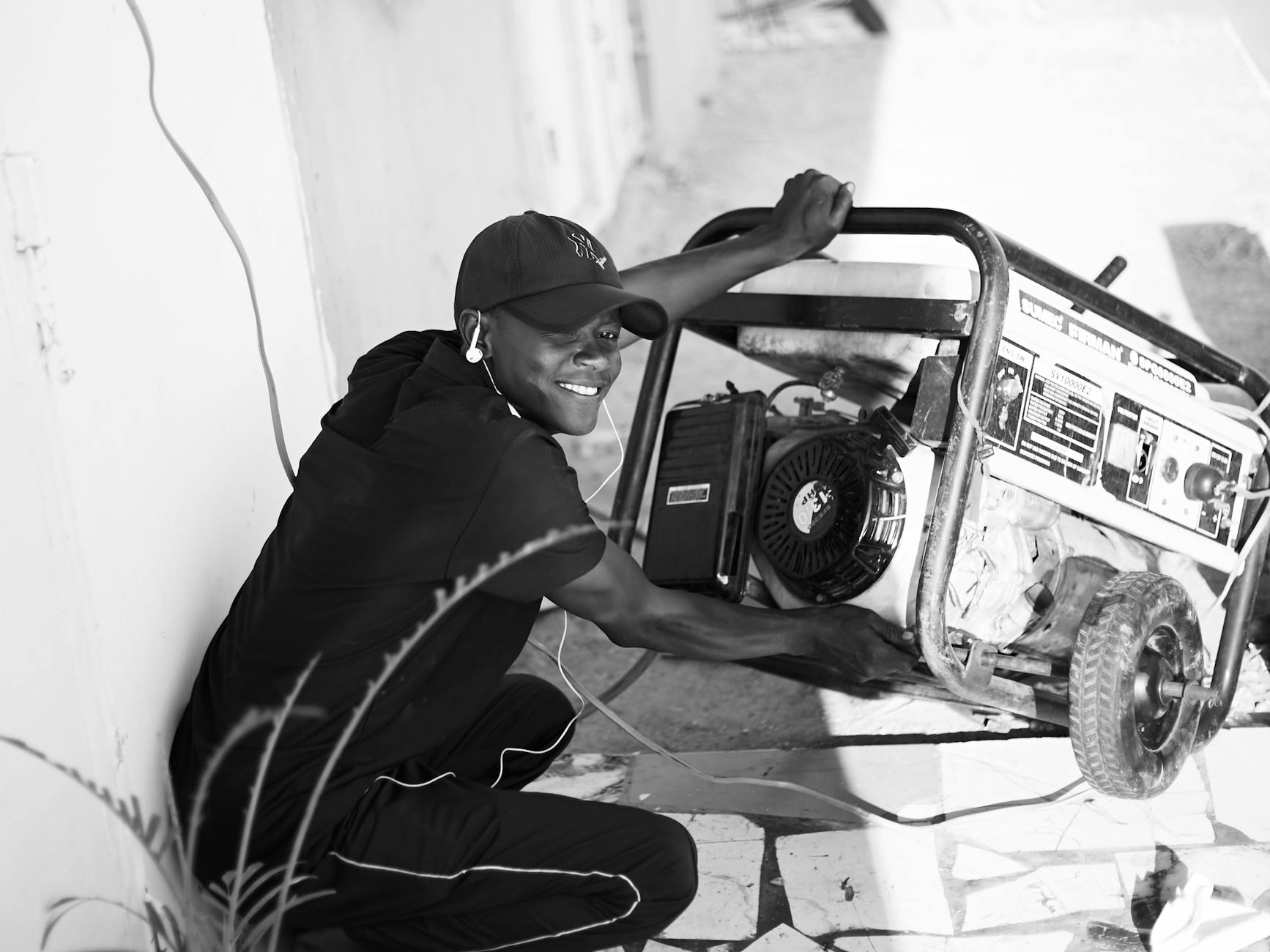 smiling man operating a portable generator outdoors