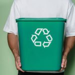 man in white t shirt holding green box